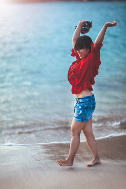 istock Woman walking by the sea 867829844