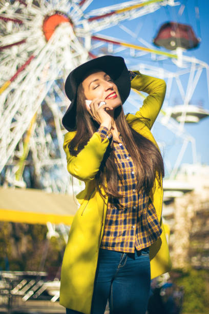 istock Happy woman using phone in amusement park 867830548