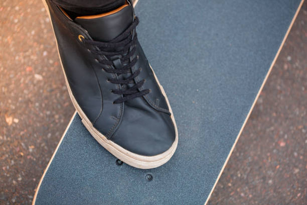 istock Leg on skateboard in black sneakers and black board 867842856