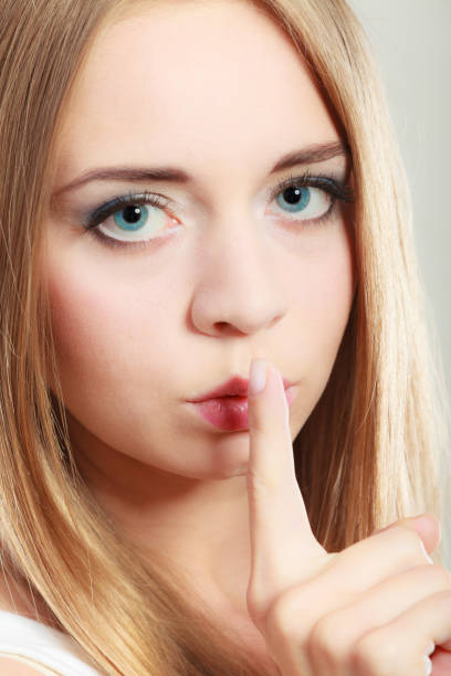 istock Woman asking for silence finger on lips 867854578