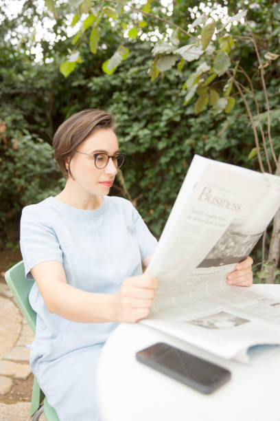 istock Businesswoman reading newspaper 867855774
