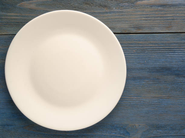 istock plate on a wooden background. plate top view. copy space 867866836