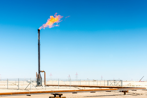 Burning torch for casing-head natural gas during oil production. Bahrain, Middle East.