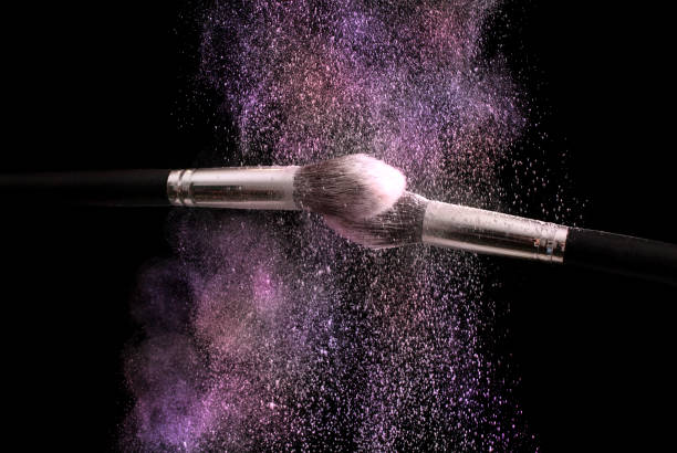 istock Powder explosion colorful dust and two make up brushes on black background 867872788
