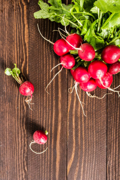 istock Red radishes in bowl on wooden table 867873058