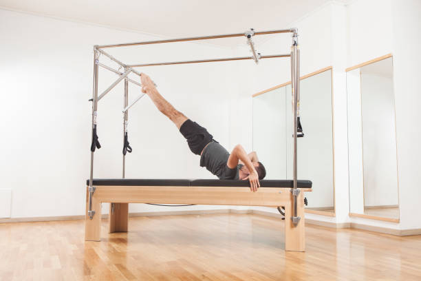 istock Pilates instructor performing exercise on cadillac equipment 867879114