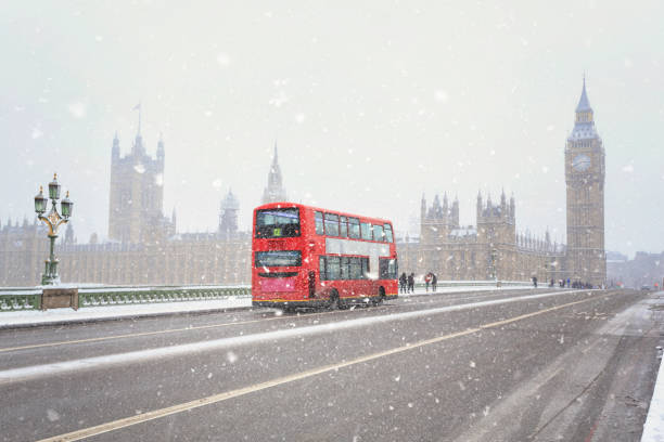 double-decker bus on westminster bridge during a snowstorm with the houses of parliament in the background in london - big ben london england uk double decker bus imagens e fotografias de stock