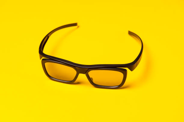 istock High angle view of black 3D glasses over yellow colored background 867895760