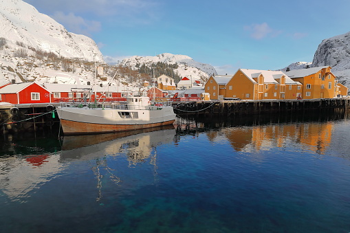 Snow covered harbor-Nusfjord fishing village-wooden fishing boat moored. Flakstadoya-Lofoten-Norway. 0485