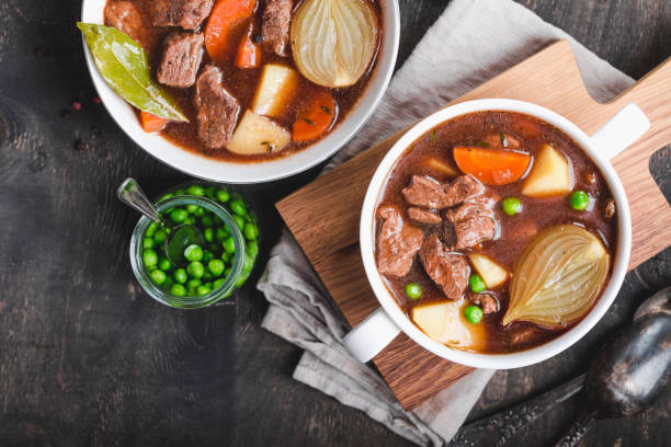 cozido de carne com carne - carrot close up silverware cutting board - fotografias e filmes do acervo