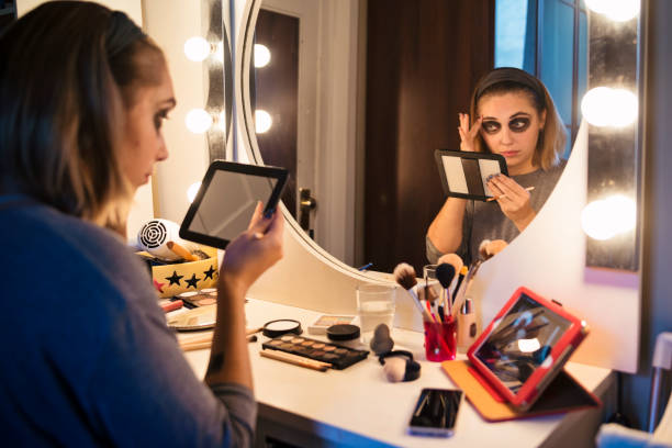 istock Young woman following a makeup tutorial on social media at home 867925572