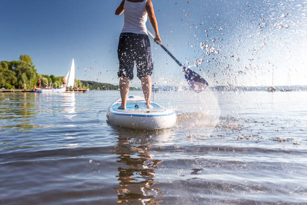 standup-paddling an einem schönen see - paddelbrett stock-fotos und bilder