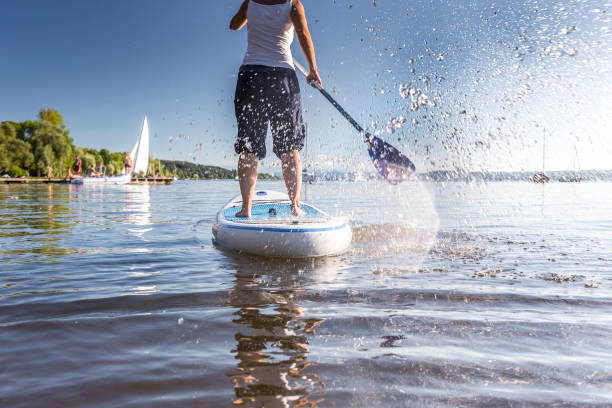 standup-peddelen op een prachtig meer - paddle surfing stockfoto's en -beelden