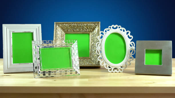 Photo frames in elegant interiors display. Row of photo frames with blank green screens in elegant table interiors display chroma key photos stock pictures, royalty-free photos & images