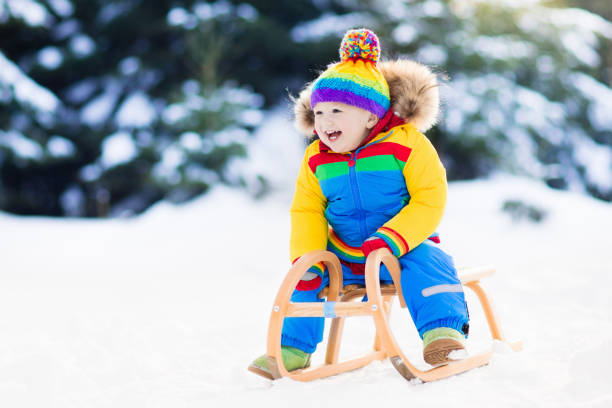istock Boy on sleigh ride. Child sledding. Kid with sledge 867941524