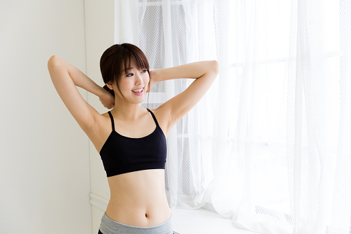 sporty asian woman relaxing in living room