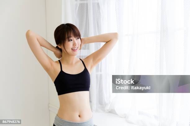 Sporty Asian Woman Relaxing In Living Room Stock Photo - Download Image Now - Sports Bra, One Woman Only, Adult