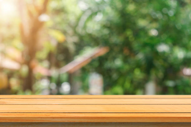 istock Wooden board empty table in front of blurred background. Perspective brown wood table over blur trees in forest background - can be used mock up for display or montage your products. spring season. 867952620