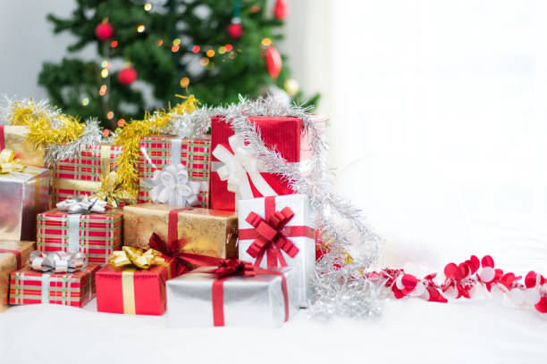 istock Many Christmas Gift boxes with Christmas tree on white bed sheet. Holiday and Celebration concept. Christmas and New year theme 867955474