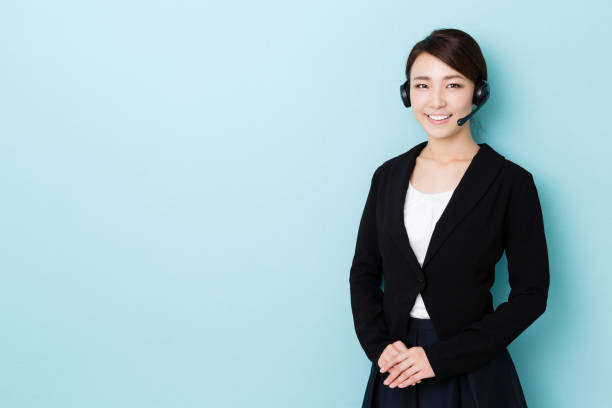 portrait de femme d’affaires asiatique isolé sur fond bleu - réceptionniste téléphonique photos et images de collection