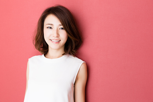portrait of young asian woman isolated on red background