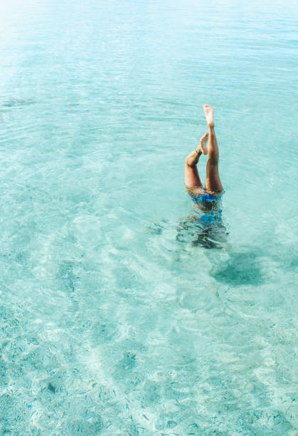istock Woman enjoying time in the ocean doing handstand 867985624