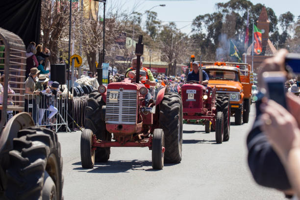 trattore vecchio stile guida lungo la strada principale di boorowa nsw - agricultural machinery retro revival summer farm foto e immagini stock