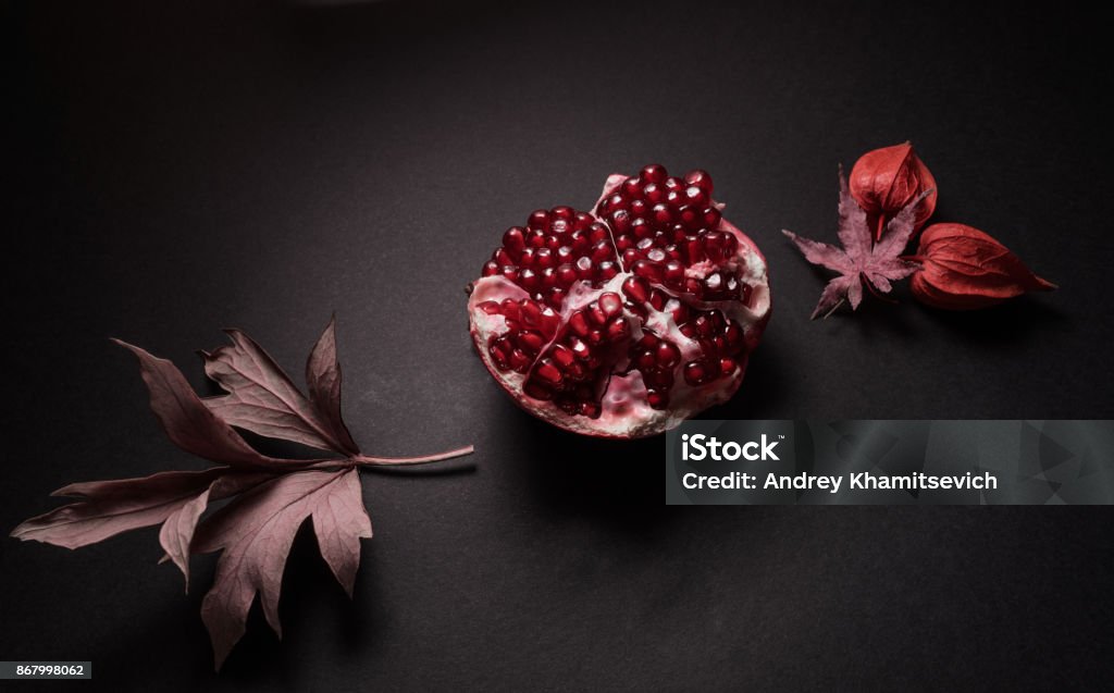 Grenades on black Perfect black and red composition with autumn fruits Art Stock Photo
