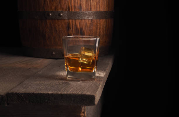 istock Glass of whiskey on rustic table.black background 867998376