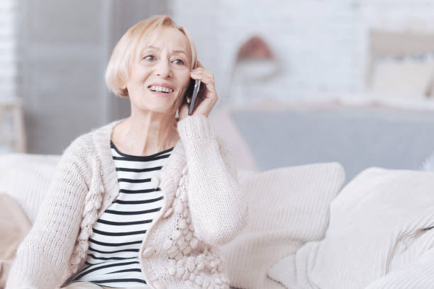 istock Radiant senior lady talking on phone at home 867998502