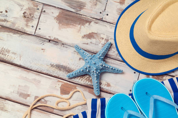 istock Summer vacation background with flip flops, starfish and hat on wooden board. View from above 868001820