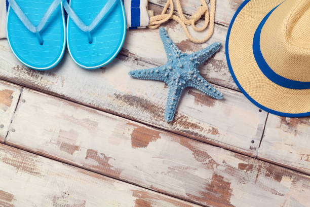 istock Summer vacation background with flip flops, starfish and hat on wooden board. View from above 868001896