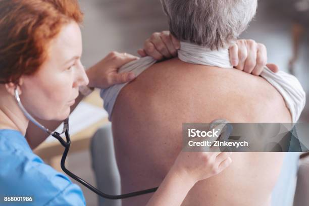 Close Up Of Doctor Listening Back Of Patient With Stethoscope Stock Photo - Download Image Now