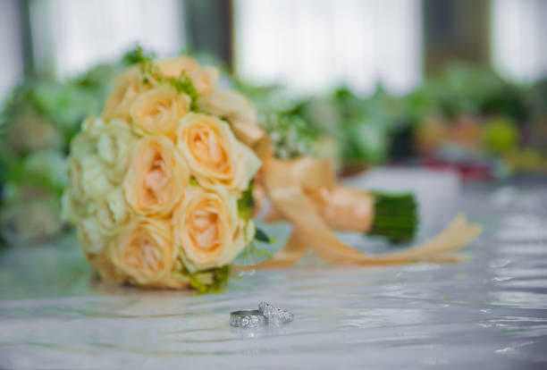 wedding rings lie on a beautiful bouquet as bridal accessories