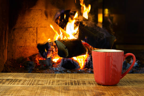 istock Coffee cup on wooden table over fireplace. 868015208
