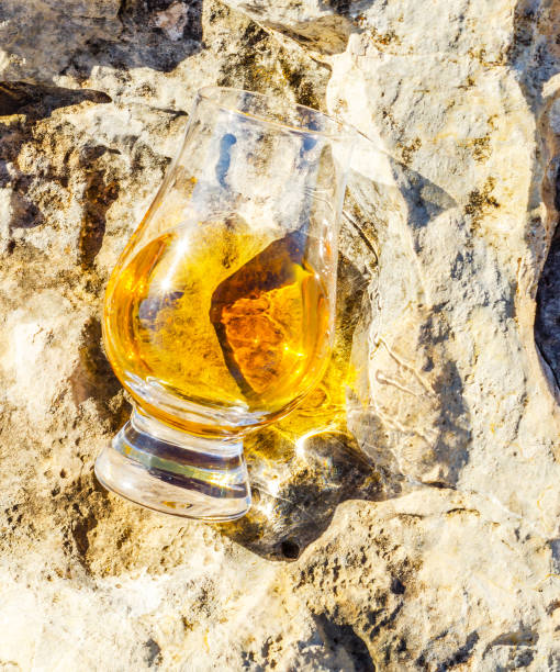 岩の上のガラスのシングルモルト スコッチ ・ ウイスキー、自然石の上を飲む - scotch on the rock ストックフォト��と画像