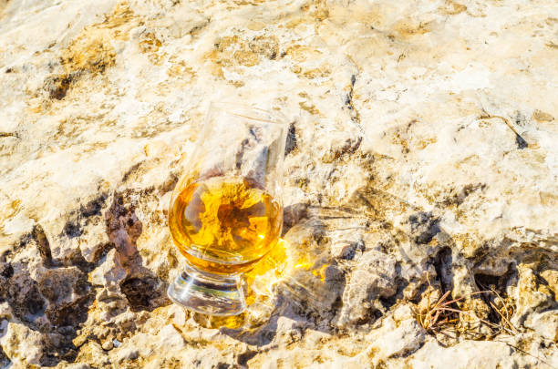 岩の上のガラスのシングルモルト スコッチ ・ ウイスキー、自然石の上を飲む - scotch on the rock ストックフォトと画像