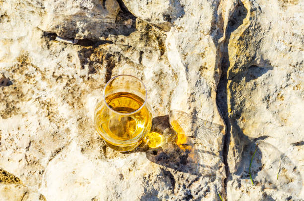 岩の上のガラスのシングルモルト スコッチ ・ ウイスキー、自然石の上を飲む - scotch on the rock ストックフォトと画像
