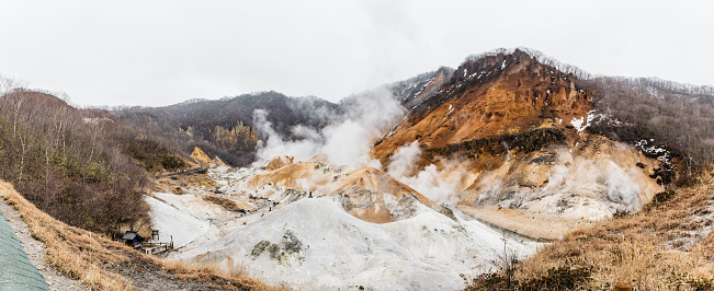 Paranomic view of Noboribetsu Jigokudani (Hell Valley): The volcano valley got its name from the sulfuric smell, extremely high heat and steam spouting out of the ground in Hokkaido, Japan.