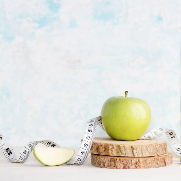 maçã verde com fita na mesa de madeira de medição. estilo de vida saudável, comida vegetariana, desintoxicação - 1466 - fotografias e filmes do acervo