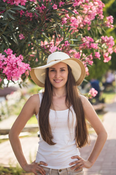 istock Smiling young woman with pink flowers as backdrop 868029680