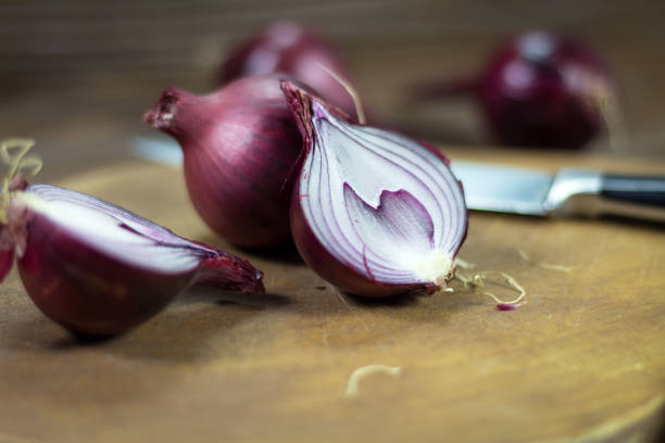 istock Organic red onion on a wooden plate 868029902