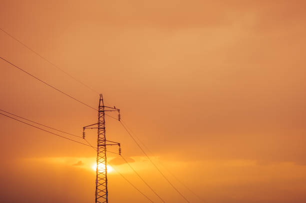 высоковольтный пост на закате. - power supply single line in a row sending стоковые фото и изображения