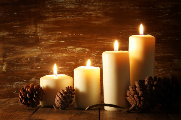 brûler des bougies et pommes de pin sur table en bois. - bougie photos et images de collection
