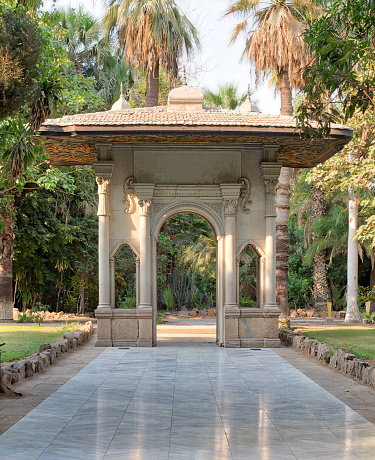 Porte-cochere (carriage porch, Gate) at a public park with marble tiled floor, trees and palms, Cairo, Egypt