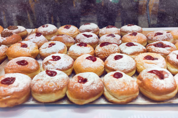 donut-sufganijot für chanukka-feier in bäckerei - miracle food stock-fotos und bilder