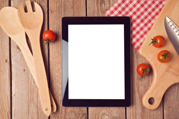 istock Digital tablet mock up template with cooking utensils and tomatoes. View from above 868049358