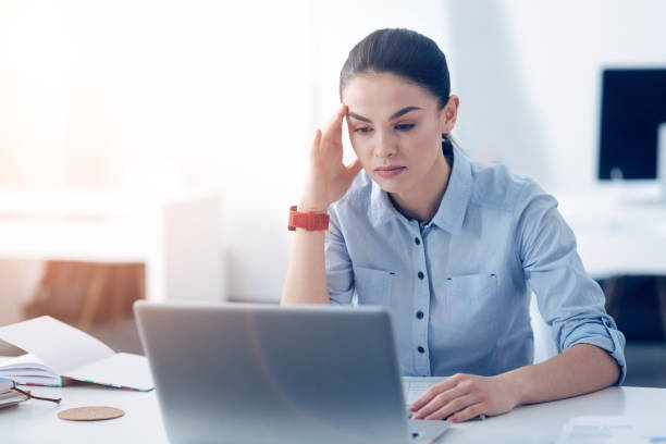 istock Tired female employee working on laptop at office 868054558