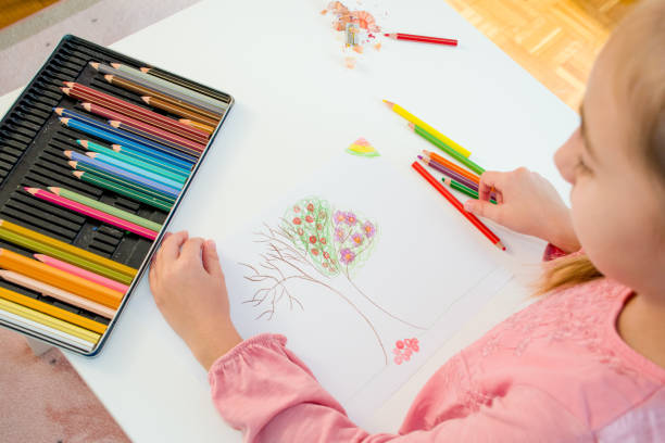 istock High Angle View Of Young Girl Drawing Tree On White Paper 868057070
