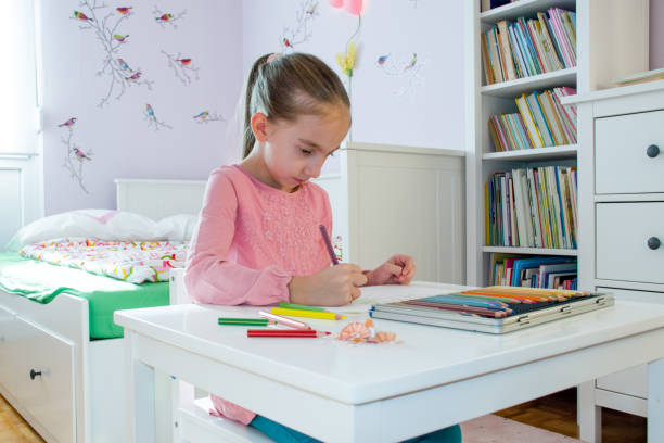 istock Young Girl Drawing In Her Bedroom 868057072